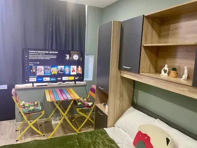 a small bedroom with a bed and a large screen at GuestHouse Karma369 in Plovdiv