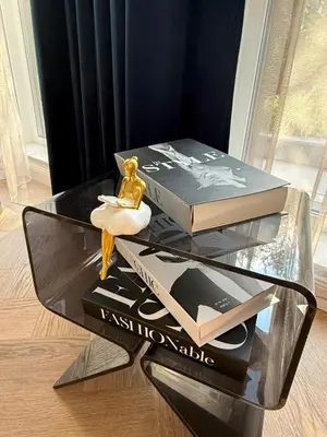 a glass table with two books on top of it at The Giraffe's apartment in Sofia