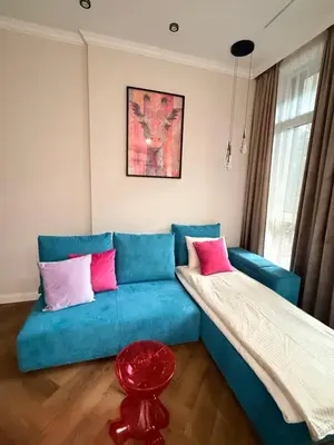 a living room with a blue couch with pink pillows at The Giraffe's apartment in Sofia