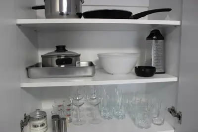 a kitchen shelf with wine glasses and utensils at Candy 26 Apartment in Velingrad