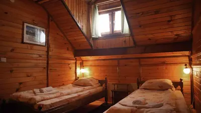 a room with two beds in a wooden cabin at Complex Popangelov in Borovets