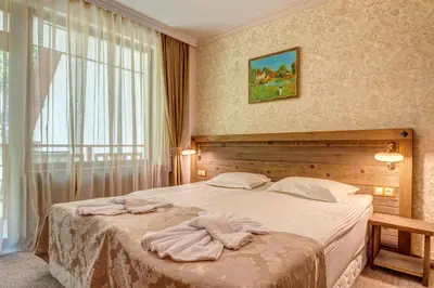 a bedroom with a bed with towels on it at Апартамент Борчето Forest Glade- Pamporovo in Pamporovo
