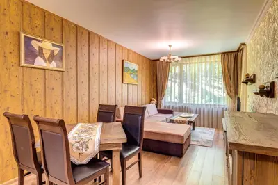a living room with a table and a couch at Апартамент Борчето Forest Glade- Pamporovo in Pamporovo