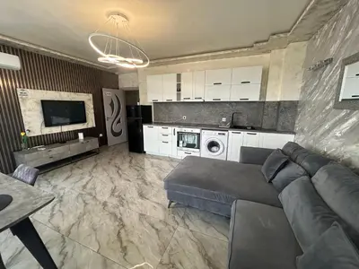 a living room with a couch and a kitchen at Платинум 8 in Plovdiv