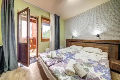 a bedroom with a bed and a brick wall at Two Cozy Mint Studios in Grand Resort Pamporovo by Flat Manager in Pamporovo