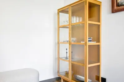 a wooden book shelf in a room with a couch at 2 Apartments, 2 Parking - Sleeps 8 - Quiet Central in Sofia