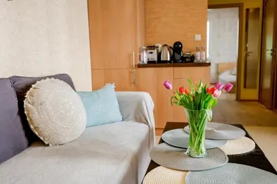 a living room with a couch and a vase of flowers on a table at My orchids apartment in the heart of Sofia in Sofia