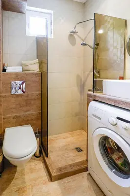 a bathroom with a toilet and a washing machine at My orchids apartment in the heart of Sofia in Sofia