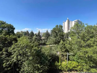 a tall building in the middle of a forest of trees at Einstein apartment in Sofia