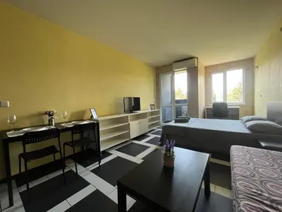 a bedroom with a bed and a tv and a couch at Einstein apartment in Sofia
