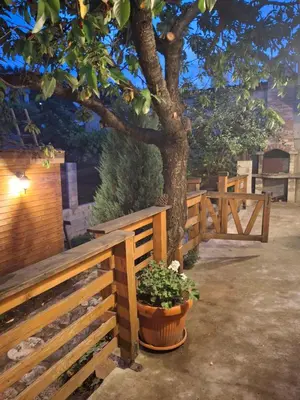a wooden fence with a tree and a potted plant at The Old Cherry House in Razlog