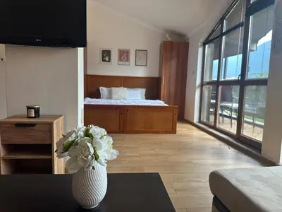 a living room with a vase with flowers on a table at Top floor and mountain views in Razlog