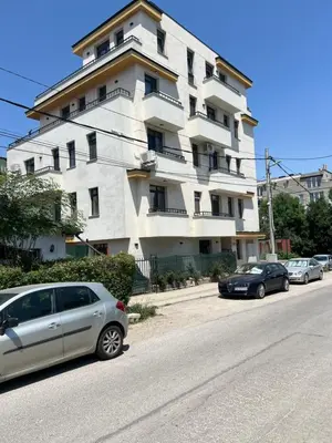 a large white building with cars parked in front of it at Cozy apartment, by Paradise Mall in Sofia