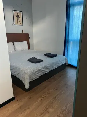 a bedroom with a bed with two black towels on it at Cozy apartment, by Paradise Mall in Sofia