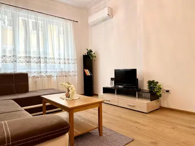 a living room with a couch and a tv at Spacious 1BR Apartment in Central Sofia, Next to University in Sofia