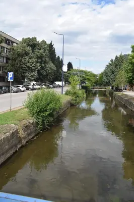 a stream of water next to a street with cars at Pirin 7 in Pazardzhik