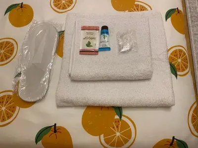 a table with a towel and a bottle of juice and oranges at Pirin 7 in Pazardzhik