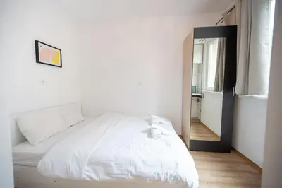 a bedroom with a white bed and a mirror at Spacious 1BDR in the Center with FREE Parking in Sofia