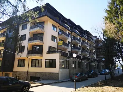an apartment building with cars parked in front of it at Ego apartment Velingrad in Velingrad
