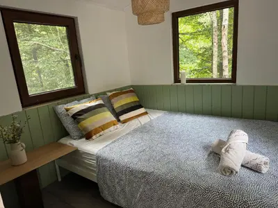 a bedroom with a bed and two windows at Bendji Land - vacation hideaway, close to Sofia in Ribarica