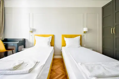 two beds in a room with white sheets at Stylish 2BD with Balcony & Desk near Vitosha Blvd by Flat Mаnager in Sofia