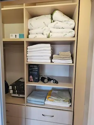 a closet with white towels and folded towels at Bright and spacious apartment with panoramic views in Sofia