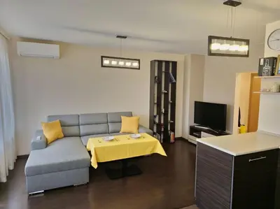a living room with a couch and a table at Bright and spacious apartment with panoramic views in Sofia