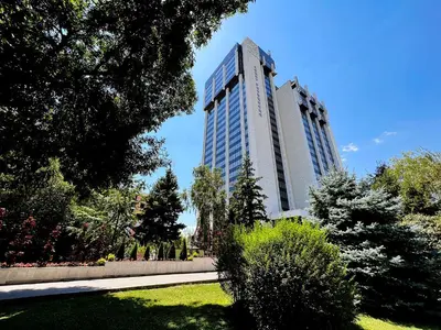 two tall buildings in a park with trees and grass at Heart & Honey - The Romantic Loft in Plovdiv