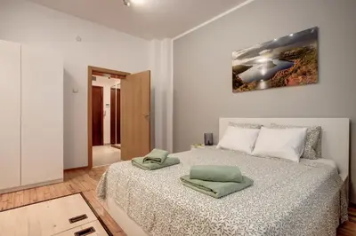 a bedroom with a bed with two green towels on it at San Stefano 4 Free Parking 2 BRDM 100m Zaimov Park in Sofia