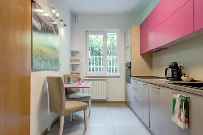 a kitchen with pink cabinets and a small table at San Stefano 4 Free Parking 2 BRDM 100m Zaimov Park in Sofia