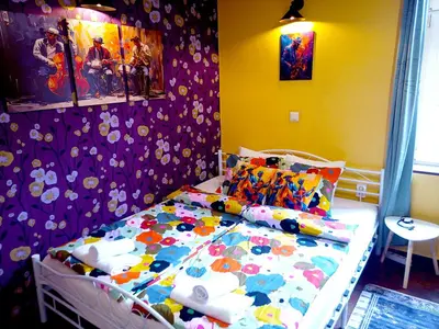 a small bedroom with a bed with colorful sheets at Jazzy Art Home - Top Center - plus Free Vouchers in Sofia