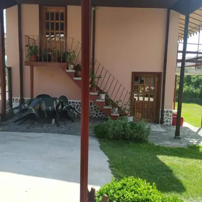 a building with a table and some stairs and some plants at Villa Silvinka in Dospat