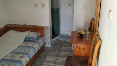 a bedroom with two beds and a wooden table at Villa Silvinka in Dospat