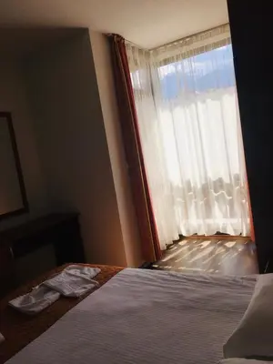 a bedroom with a bed with a window at Beautiful two bedroom 4th floor apartment in Elegant Luxe Hotel with pool, sauna, gym and steam room in Bansko