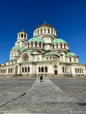 a large building with a person standing in front of it at Bright, City Centre, 1BR Apartment , Next to Sofia University in Sofia