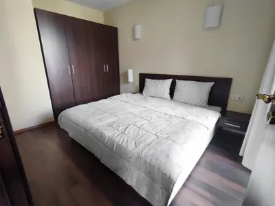 a bedroom with a large bed with a wooden door at Aspen Apartment A208 3OOm from Gondola in Bansko