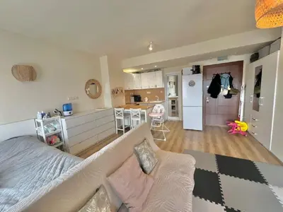 a large living room with a couch and a kitchen at Слънчево Студио Алпин Банско! in Bansko