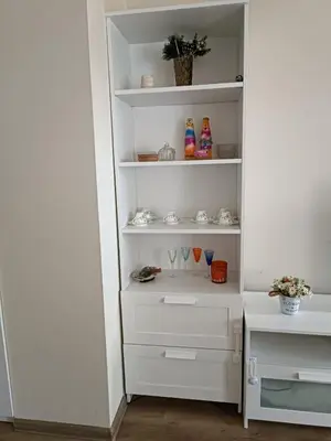 a white closet with white shelves and glasses at Слънчево Студио Алпин Банско! in Bansko