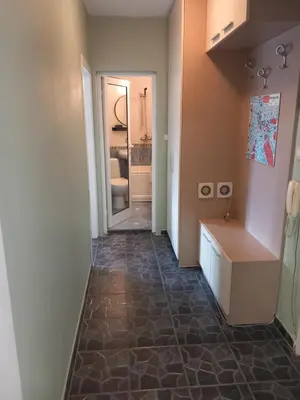 a hallway leading to a bathroom with a tile floor at the green apart in Sofia