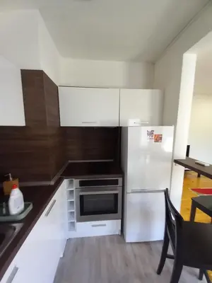 a kitchen with a white refrigerator and a table at the green apart in Sofia