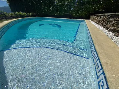 a swimming pool with blue water in it at Къщата на тати in Garmen