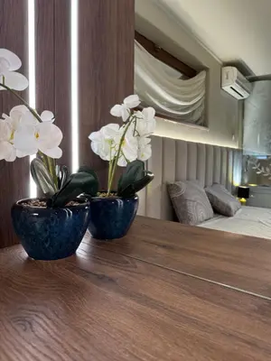 two blue vases with white flowers on a wooden table at Къщата на тати in Garmen