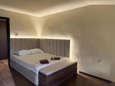 a bedroom with a bed with two bags on it at Къщата на тати in Garmen