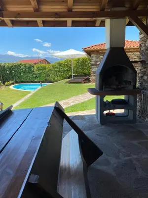 a outdoor grill on a patio with a table at Къщата на тати in Garmen