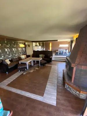 a large living room with couches and a table at Къщата на тати in Garmen