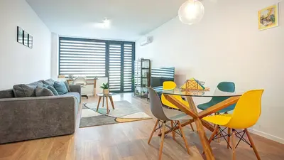 a living room with a table and yellow chairs at College Flat - Wi-Fi with 600 Mbit speed in Sofia