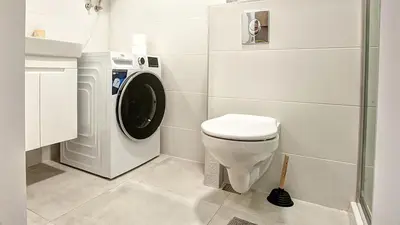 a bathroom with a washing machine and a toilet at College Flat - Wi-Fi with 600 Mbit speed in Sofia