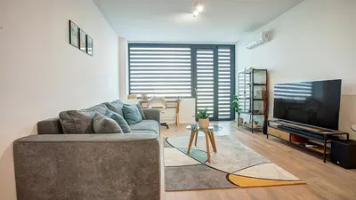 a living room with a couch and a flat screen tv at College Flat - Wi-Fi with 600 Mbit speed in Sofia