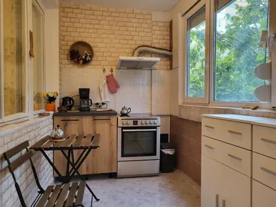 a kitchen with a stove and a table in it at Apartament KETI улица Христо Максимов 56 вхВ in Sofia