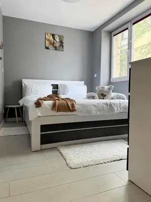 a bedroom with a bed with white sheets and a window at Top City Centre Apartment 122 in Sofia